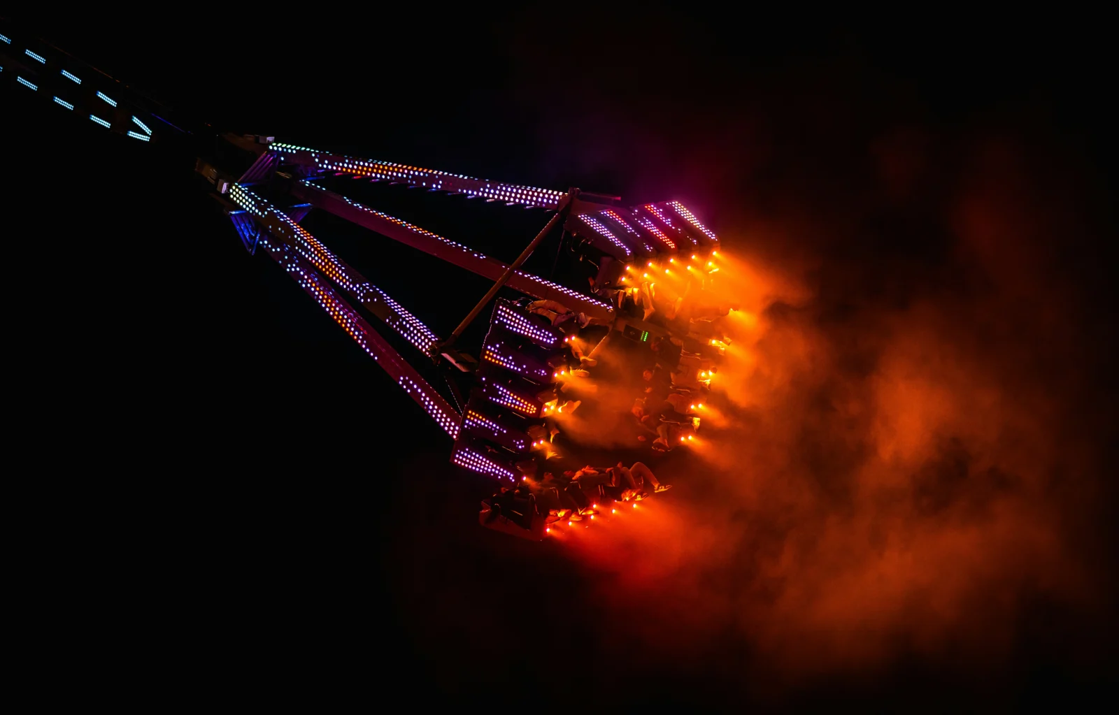 Thrill ride with fiery exhaust at night